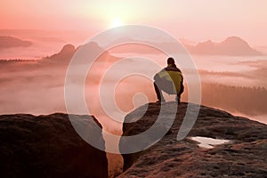 Man on peak of sandstone rock in national park Saxony Switzerland watching to Sun. Beautiful moment