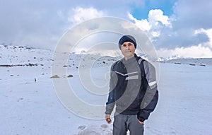 Man at peak summit snow cap mountains with bright blue sky at day