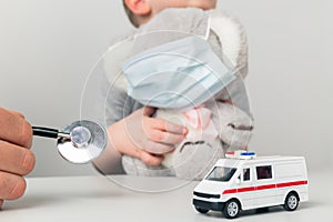 Man pediatrian with child holding toy using stethoscope in the cabinet.