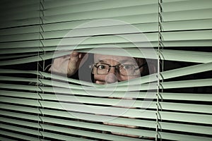 Man peeking through blinds