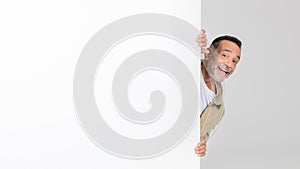 Man Peeking Out From Behind White Wall photo