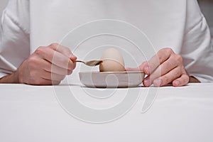 Man peeling an egg on a stand close-up of hands