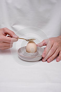 Man peeling an egg on a stand close-up of hands