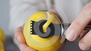 Man peeling fresh lemon with zester, closeup view