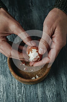 man is peeling a hard-boiled egg