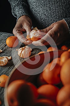 man peeling a mandarin orange