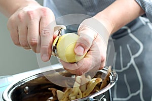 Man peeling potatoes. Kitchen working. Prepare food