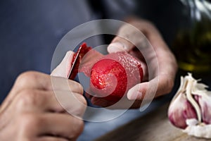 Man peeling a scalded tomato