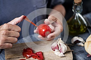 Man peeling a scalded tomato