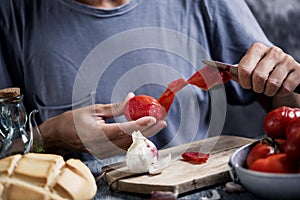 Man peeling scalded tomatoes