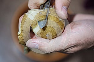 A man peels potatoes with a knife especially