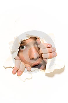 Man peeping through hole on paper photo