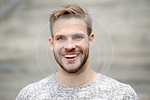 Man with perfect brilliant smile unshaven face defocused background. Guy happy emotional expression outdoors. Bearded