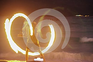 man performing fire show dancing with flame at night