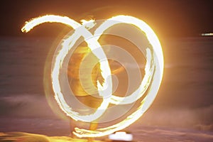 man performing fire show dancing with flame at night