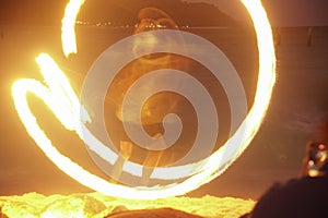 man performing fire show dancing with flame at night