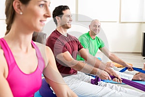 Man performing foot exercises with thera band