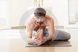 Man performing a Janu sirsana yoga pose