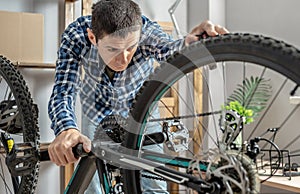 Man is performing maintenance on his mountain bike. Concept of fixing and preparing the bicycle for the new season