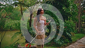 Man performing traditional fire dance in tropical garden setting