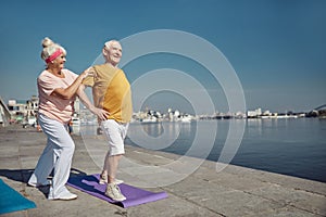 Man performing a warm-up exercise on the quay