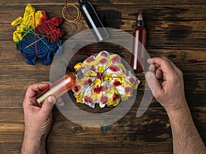 A man performs a chaotic coloring of a tie dye T-shirt