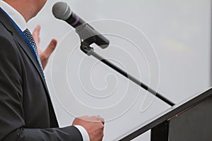 Man performs on conference - speaks in microphone for audience