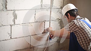 The man performs electrical installation work