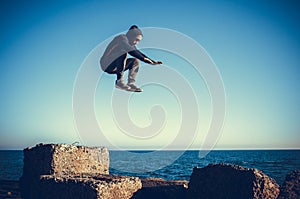Man performs freerunning jump on stones