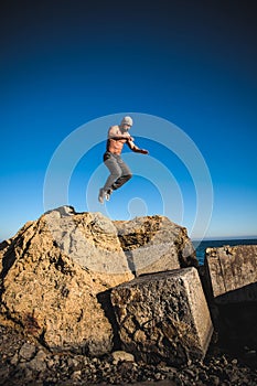 Man performs freerunning jump on stones