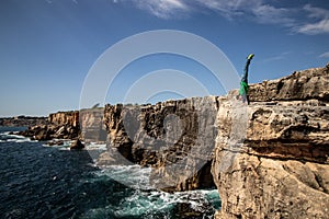 Man performs a handstand on the edge of cliff. Concept of extreme, freedom and braves