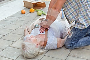 Man performs a heart massage on an senior lady