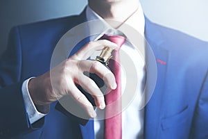 Man is perfuming himself