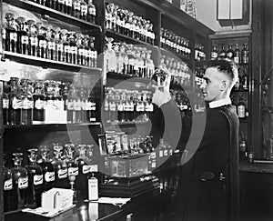 Man in a pharmacy mixing medicine