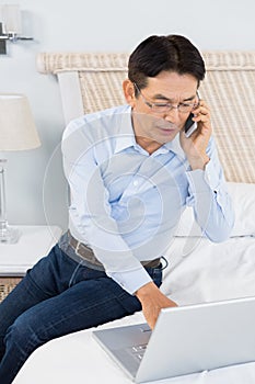 Man on a phone call using laptop