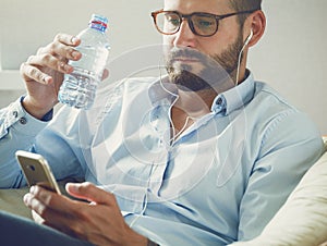Man with phone and drinking water