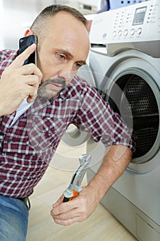 man on phone next to washing machine
