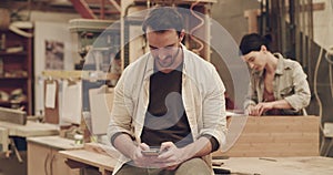 Man, phone and online communication in carpenter workshop for small business planning. Male person with a smartphone for