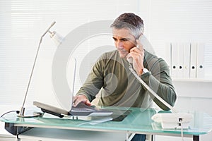 Man on the phone and using laptop