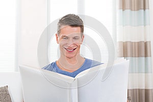 Man With Photo Book Sitting On Sofa