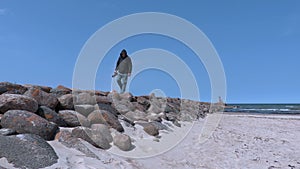Man with photo camera on the stone pier by the sea