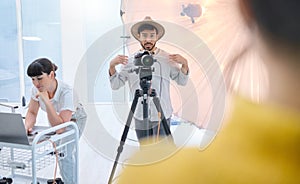 Man, photographer and camera in studio with model showing poses, expression or style for photoshoot. Male in photography