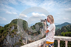 Man photographer shooting landscape standing on a viewpoint