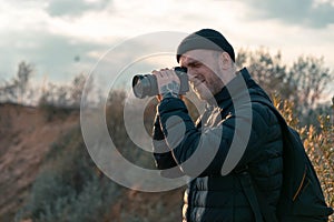 Man photographer taking photo of sunset and mountains. Travel Lifestyle. active hobby. vacation hiking climbing