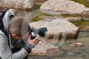 Man photographer taking picture of mountain lake