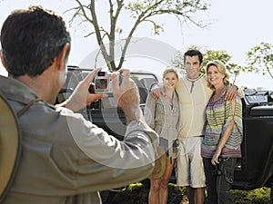 Man Photographing Friends By Jeep