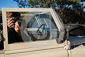 Man photographing while sitting in off road vehicle