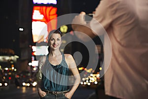 Man Photographing Woman In Times Square At Night