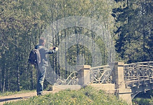 The man photographs the bridge on phone, toning