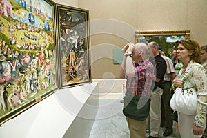 Man photographs The Garden of Earthly Delights by Hieronymus Bosch, in the Museum de Prado, Prado Museum, Madrid, Spain